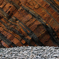 Buy canvas prints of Orange Cliff Face & Grey Pebbles by Dave Bell
