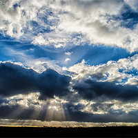 Buy canvas prints of Breaking in the clouds, revealing the rays of beau by 