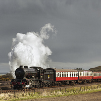Buy canvas prints of Steam train and storm clouds on the Norfolk Coast  by Ian Duffield