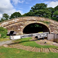 Buy canvas prints of Canal Bridge and Lock Lancaster Canal by Gary Kenyon
