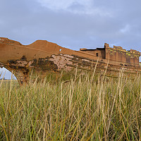 Buy canvas prints of Old Rusty boat through the grasses at Fleetwood by Gary Kenyon