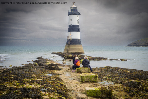 Penmon lighthouse sits at the start of the Menai Strait across f Picture Board by Peter Stuart