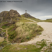 Buy canvas prints of The stone cross overlooks the Llanddwyn beaches and lighthouses  by Peter Stuart