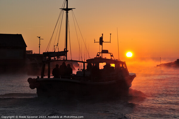 A fishing boat heads out at sunrise Picture Board by Rosie Spooner
