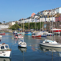 Buy canvas prints of Colourful boats and houses at Brixham Harbour by Rosie Spooner