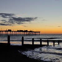 Buy canvas prints of Silhouetted sunrise  of Teignmouth Pier and Groyne by Rosie Spooner