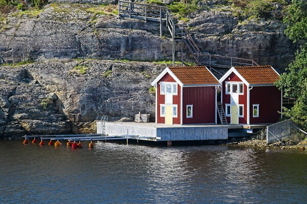 Boathouses on Orust Island in Western Sweden Picture Board by Martyn Arnold