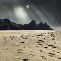 Buy canvas prints of Shafts of light over Three Cliffs Bay by Leighton Collins