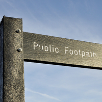 Buy canvas prints of Public footpath sign set against a blue sky by Frank Irwin