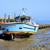 Buy canvas prints of A fishing boat sits high and dry in Rhos-on-Sea by Frank Irwin