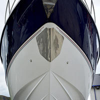 Buy canvas prints of  The bow of a yacht set against a blue sky. by Frank Irwin