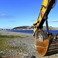 Buy canvas prints of  A 'Caterpillar' excavator resting its bucket on t by Frank Irwin