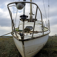 Buy canvas prints of  A slightly battered yachy lies on Heswall Beach,  by Frank Irwin