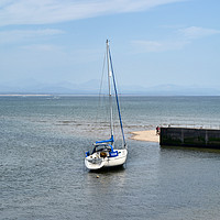 Buy canvas prints of A yacht lies at anchor in Abersoch Harbour by Frank Irwin