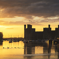 Buy canvas prints of The setting sun at Caernarfon Castle Wales by Chris Warren