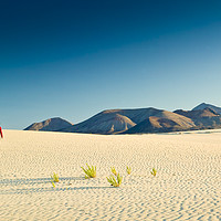 Buy canvas prints of A lone figure walking on Sand dunes Corralejo  by Chris Warren