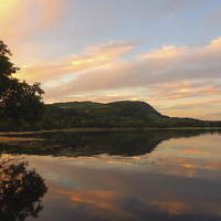 Buy canvas prints of Serene Sunset Reflections at Scotlands Only Lake by Tommy Dickson