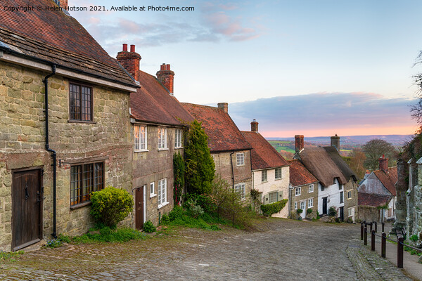 Sunset over cottages on a cobbled street Picture Board by Helen Hotson