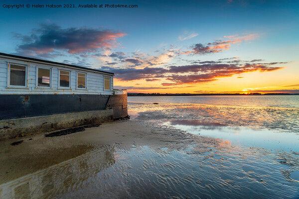 Sunset over an old boat on Bramble Bush Bay at Studland in Poole Picture Board by Helen Hotson
