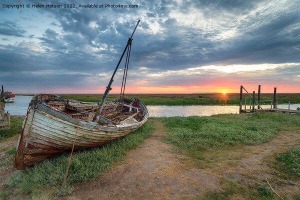 Sunrise over an old fishing boat on the shore at Thornham Picture Board by Helen Hotson