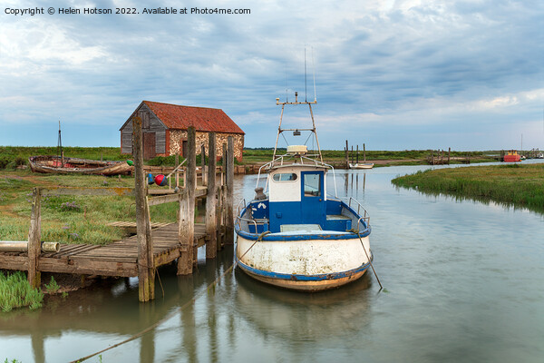 A fishing boat moored at a wodden jetty at Thornham Picture Board by Helen Hotson