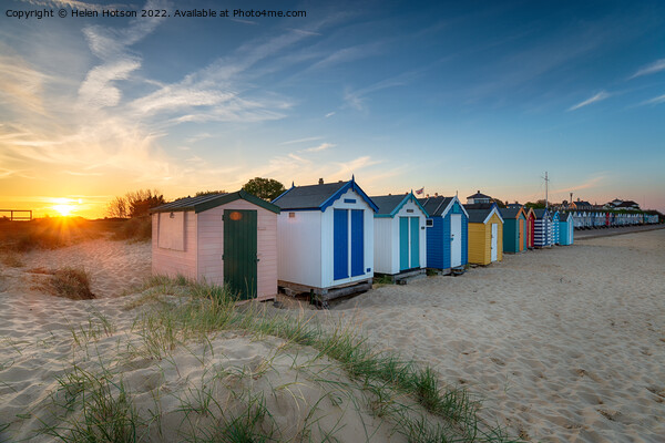Sunset over a row of beach huts at Southwold  Picture Board by Helen Hotson