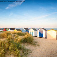 Buy canvas prints of Colourfull beach huts in the sand dunes at Southwold by Helen Hotson