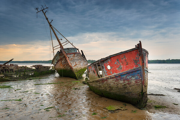 Old boat wrecks under a stormy sky Picture Board by Helen Hotson