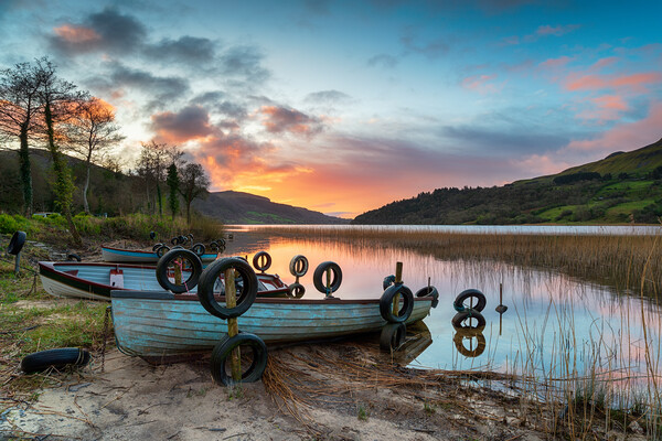 Beautiful sunrise over boats at Glencar Lough Picture Board by Helen Hotson