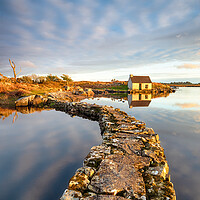 Buy canvas prints of An old stone jetty across a lake leading to a small cottage by Helen Hotson