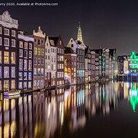 Buy canvas prints of Amsterdam At Night Dancing Canal Houses Damrak  by Chris Curry