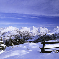 Buy canvas prints of Bench looking to Five Sisters of Kintail in Snow by Pearl Bucknall