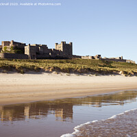 Buy canvas prints of Bamburgh Castle Reflected on Beach by Pearl Bucknall