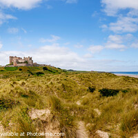 Buy canvas prints of Bamburgh Castle over Sand Dunes by Graham Prentice