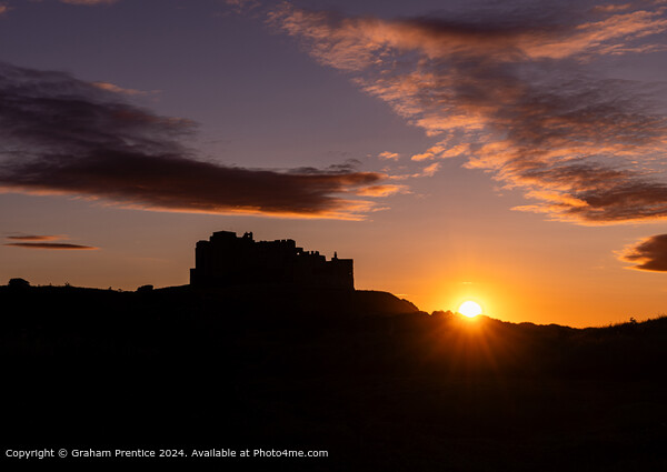 Bamburgh Castle Sunset Silhouette at Sunset Picture Board by Graham Prentice