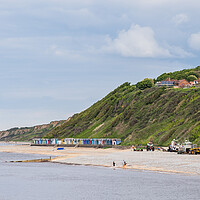 Buy canvas prints of Beach huts sandwiched between the sea and cliffs at Cromer by Jason Wells