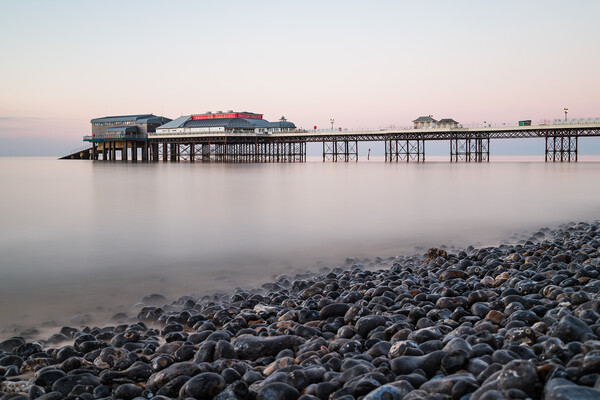 Cromer pier seen over the pebble beach Picture Board by Jason Wells