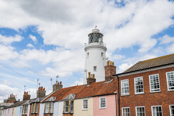 Southwold Lighthouse behind colourful houses Picture Board by Jason Wells