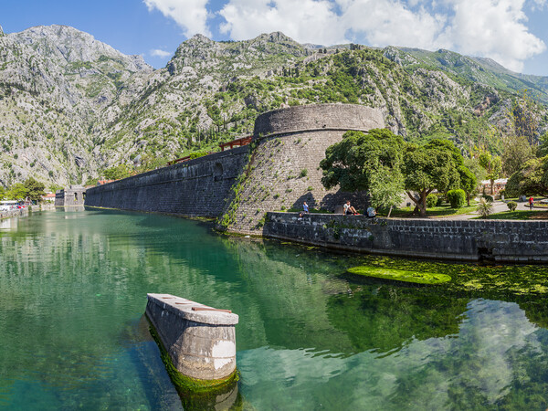 Tourists sit next to the moat in Kotor Picture Board by Jason Wells