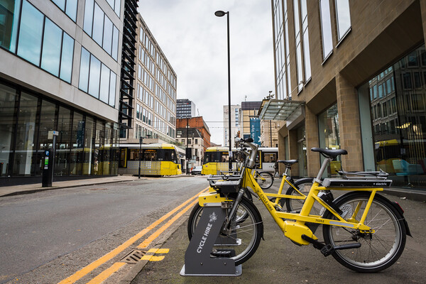 Yellow cycles for hire in Manchester Picture Board by Jason Wells