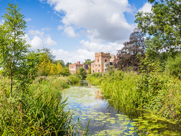 Oxborough Hall over a channel of water Picture Board by Jason Wells