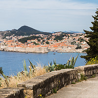 Buy canvas prints of Dubrovnik's old town seen over a curving coastal r by Jason Wells