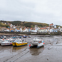 Buy canvas prints of Boats lined up in the bay at Staithes at low tide by Jason Wells