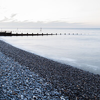 Buy canvas prints of Groynes stretch out from the pebbly beach at Sheringham by Jason Wells