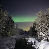 Buy canvas prints of The Aurora Borealis dances over a wintered stream by Teresa Cooper