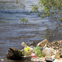 Buy canvas prints of garbage plastic bottles damage river after flood  by Arletta Cwalina