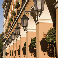 Buy canvas prints of Row of lamps on columns of building  by Arletta Cwalina