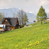 Buy canvas prints of Bucolic spring meadow and wooden house by Arletta Cwalina