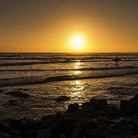 Buy canvas prints of Surf sunset silhouette  by Dean Merry