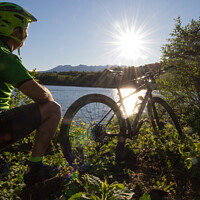 Buy canvas prints of Mountain biking at sunset by the lake by Fabrizio Malisan